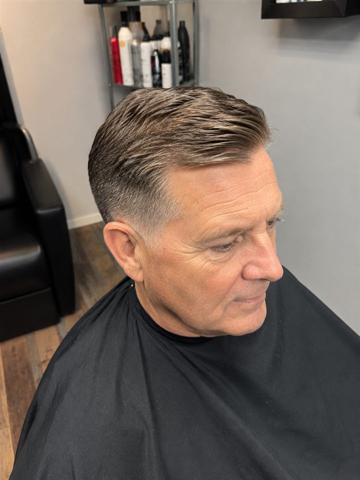 Men's haircut with short faded sides and textured grey hair on top