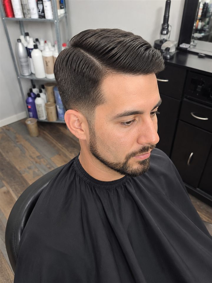 Men's haircut with clean side part, faded sides, and styled top