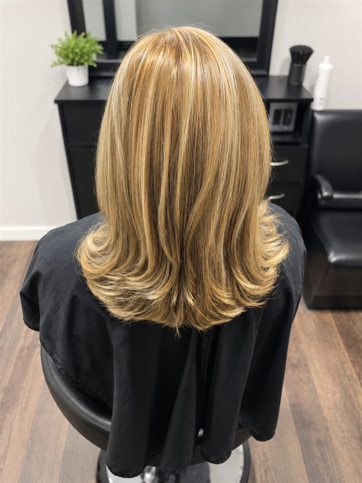 Shoulder-length blonde hair with highlights and flipped layered ends